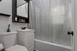 Full bath with shower / tub combo with curtain and vanity