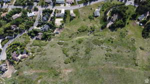 Aerial view of property and surrounding area featuring nearby suburban area