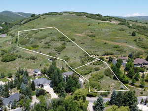Aerial view of property's location with property parcel outlined and a mountain backdrop
