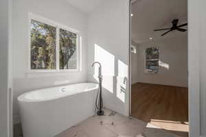Full bathroom with a freestanding tub, ceiling fan, recessed lighting, and marble finish flooring