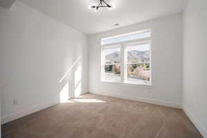 Empty room featuring light colored carpet and baseboards