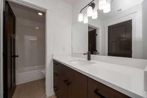 Bathroom featuring vanity, shower / bathtub combination, and light tile patterned flooring