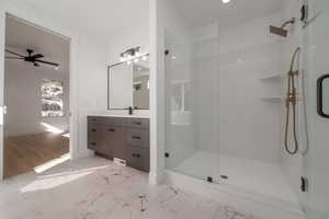 Full bath featuring vanity, a stall shower, light marble finish flooring, recessed lighting, and ceiling fan