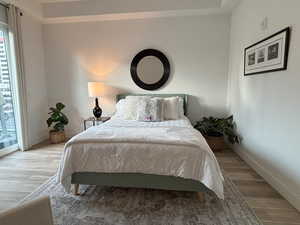 Primary suite featuring access to exterior and wood finished floors and open concept feel.