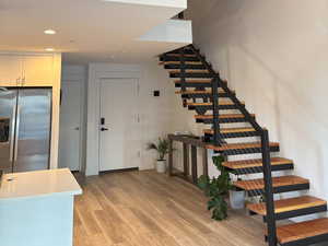 Entrance and stairway featuring wood finished floors and recessed lighting