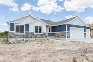 View of front of house with stone siding, a garage, concrete driveway, and board and batten siding