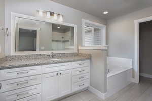 Full bath featuring vanity, a shower stall, a garden tub, and recessed lighting