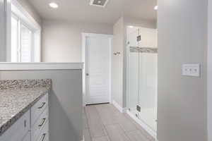 Full bath featuring a stall shower, vanity, and recessed lighting
