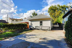 Rear view of property featuring a chimney and roof with shingles