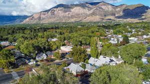 Aerial view of property and surrounding area with mountains and nearby suburban area