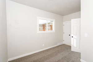Unfurnished bedroom with carpet flooring and baseboards