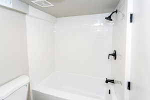 Bathroom with  shower combination and a textured ceiling