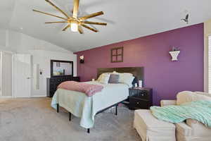 Bedroom featuring vaulted ceiling, carpet, and a ceiling fan