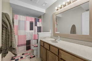 Full bath featuring vanity, light tile patterned floors, and a shower with curtain