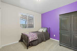 Bedroom with light carpet and a textured ceiling