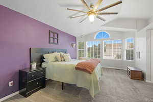 Bedroom with carpet flooring, vaulted ceiling, and ceiling fan