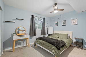 Bedroom with light carpet and a ceiling fan