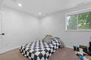 Bedroom with light carpet and recessed lighting