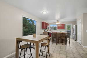 Dining area with light tile patterned floors, a ceiling fan, and a textured ceiling