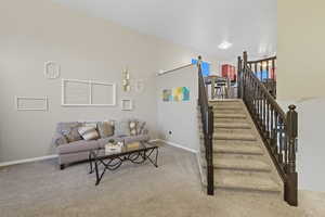Living room featuring light colored carpet and stairway