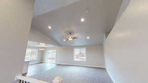 Unfurnished living room with lofted ceiling, a chandelier, light carpet, and recessed lighting