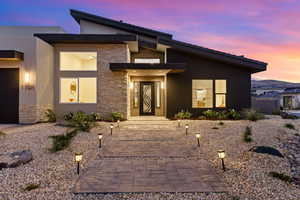 Contemporary house with stone siding, stucco siding, and a mountain view