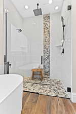 Full bath with a shower stall, tile walls, a freestanding tub, wood finished floors, and recessed lighting