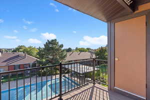 Balcony featuring view of pool area and a residential view