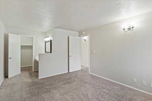 Bonus room with carpet flooring and a textured ceiling