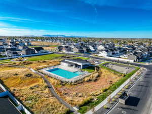 Aerial view of residential area featuring a pool area and a mountainous background