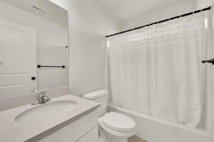 Bathroom with shower / bathtub combination with curtain and vanity