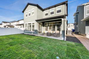 Rear view of property featuring a patio area, stucco siding, a fenced backyard, and an outdoor living space