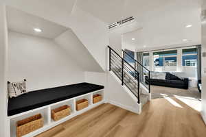 Stairs with recessed lighting and wood finished floors