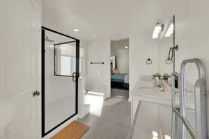 Primary en-suite bathroom featuring a stall shower, double vanity, connected bathroom, light tile patterned floors, and recessed lighting