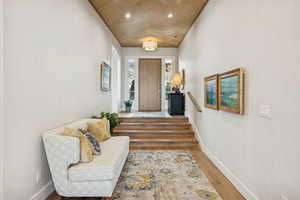 Entryway with wood finished floors, recessed lighting, and stairs