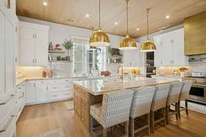 Kitchen featuring open shelves, white cabinets, backsplash, light stone countertops, and wooden ceiling