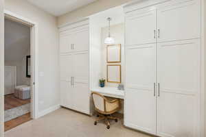 Office area with built in study area and light colored carpet