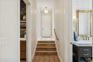 Stairs with wood finished floors and baseboards