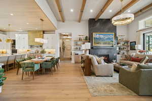 Living room with light wood-type flooring, beam ceiling, a high end fireplace, and recessed lighting