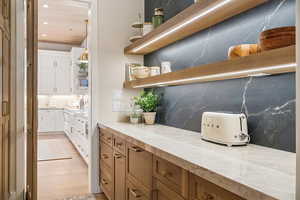 Bar with decorative backsplash, brown cabinetry, white cabinets, open shelves, and recessed lighting