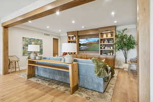 Living room featuring wood finished floors, crown molding, and recessed lighting