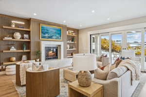 Living area featuring recessed lighting, a fireplace, wood finished floors, and built in shelves