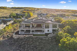 Rear view of property with a metal roof, a standing seam roof, a patio area, and a chimney