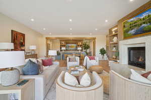 Living area with a fireplace, recessed lighting, wood finished floors, and built in shelves