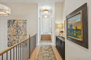 Corridor featuring light wood-style floors and stairway