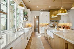 Kitchen featuring open shelves, white cabinets, light wood-type flooring, decorative light fixtures, and wood ceiling