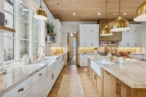 Kitchen with open shelves, white cabinetry, wood ceiling, recessed lighting, and light stone countertops