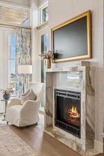 Sitting room featuring a glass covered fireplace and wood finished floors