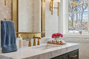 Bathroom view of wallpapered walls and vanity