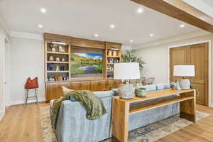 Living area featuring crown molding, light wood-style flooring, and recessed lighting